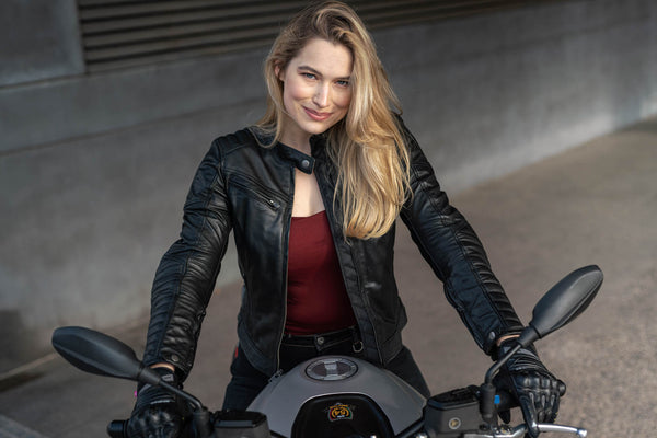 A blond woman on a motorcycle wearing Black leather motorcycle jacket for women from Shima
