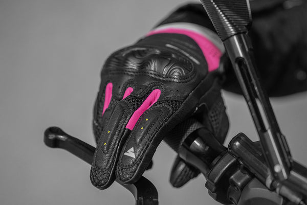 A hand on a motorcycle stearing wheel wearing Black and pink women's motorcycle gloves Rush lady  from Shima
