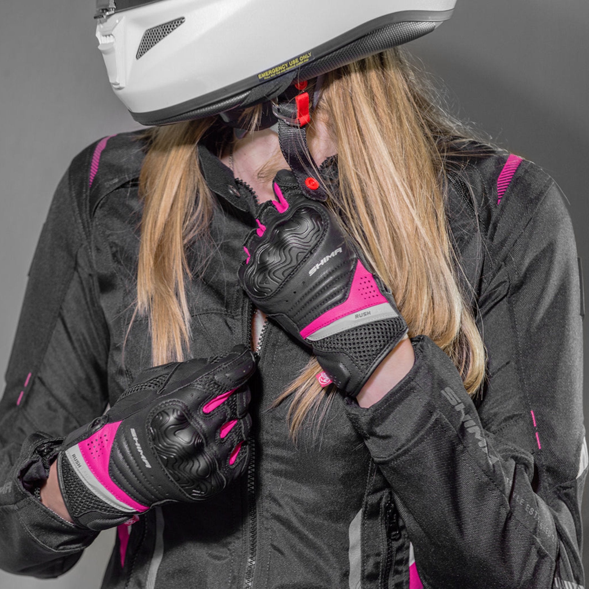 a woman zipping her jacket wearinh Black and pink women&#39;s motorcycle gloves Rush lady  from Shima