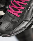 A foot wearing Rebel waterproof motorcycle sneakers with pink laces from Shima changing motorcycle gear