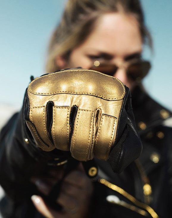 woman&#39;s fist wearing black Eudoxie mc glove with golden flames 