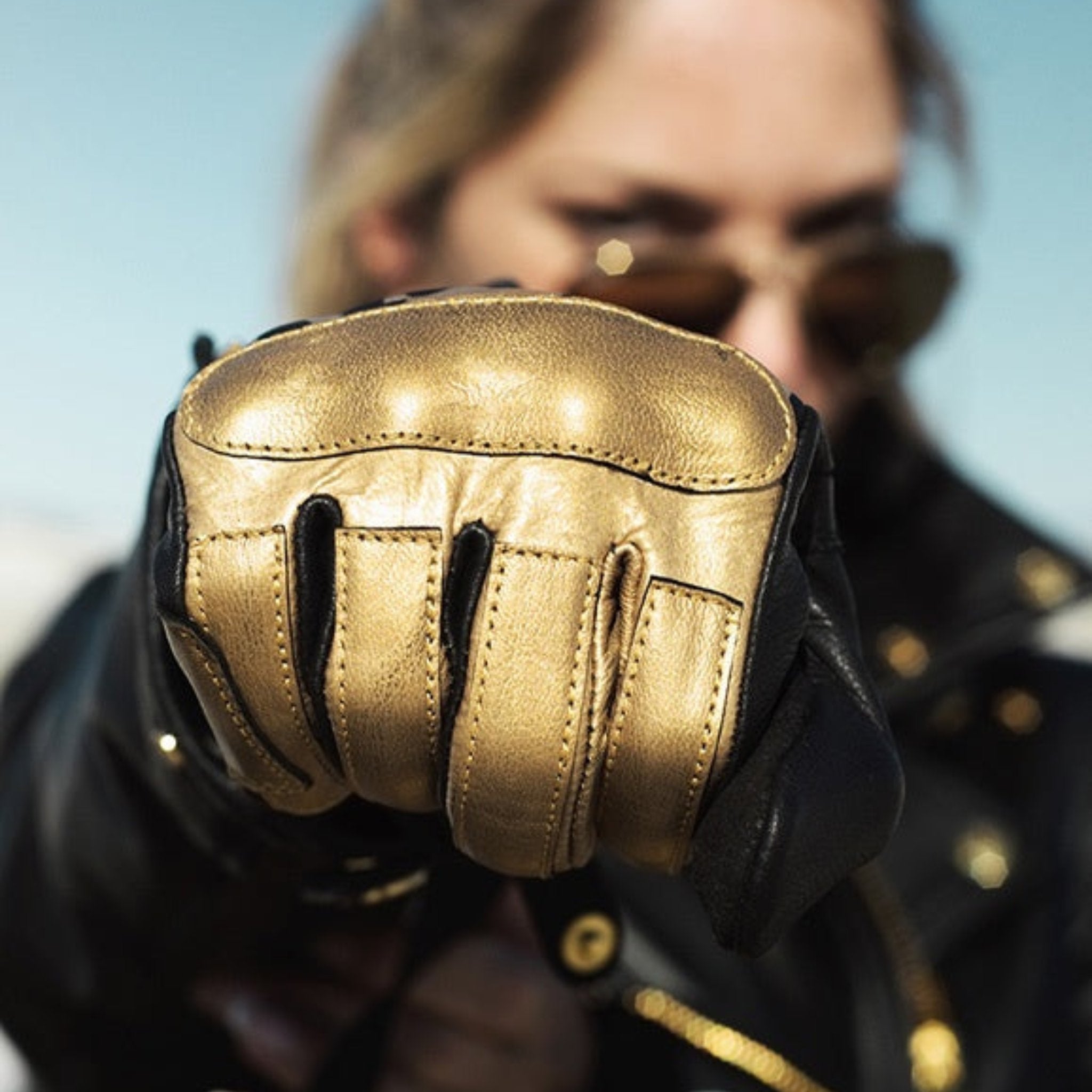 woman&#39;s fist wearing black Eudoxie mc glove with golden flames 