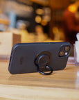 A phone on the table leaning on the ring holder 