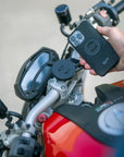 A phone being mounted with the SPC mounts  on a red motorcycle 