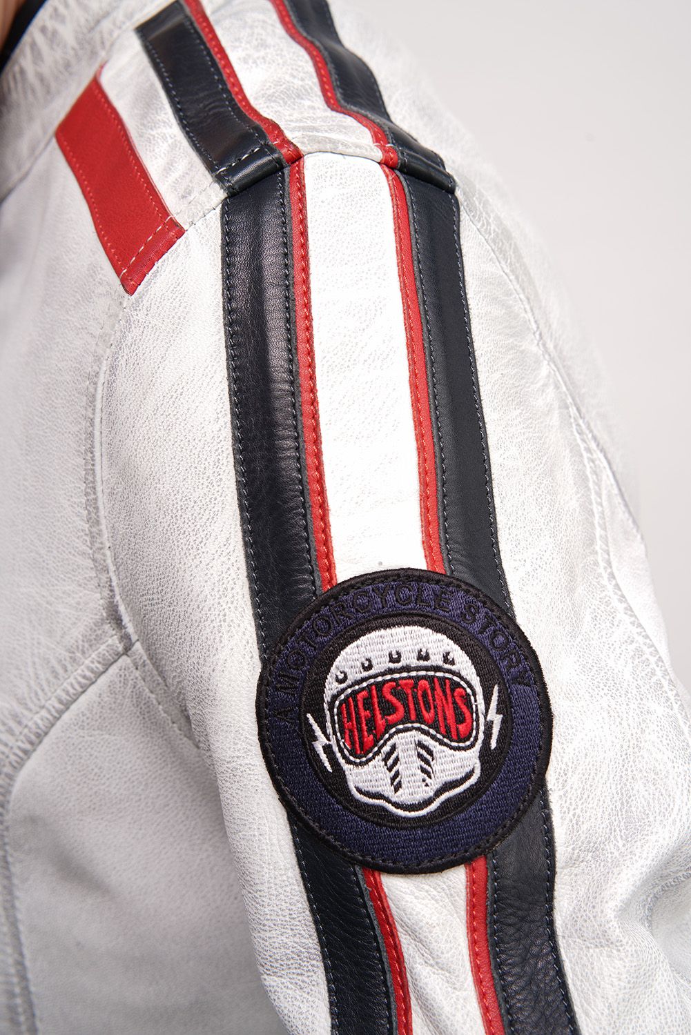A close up of the Helstons patch on a white motorcycle jacket with stripes