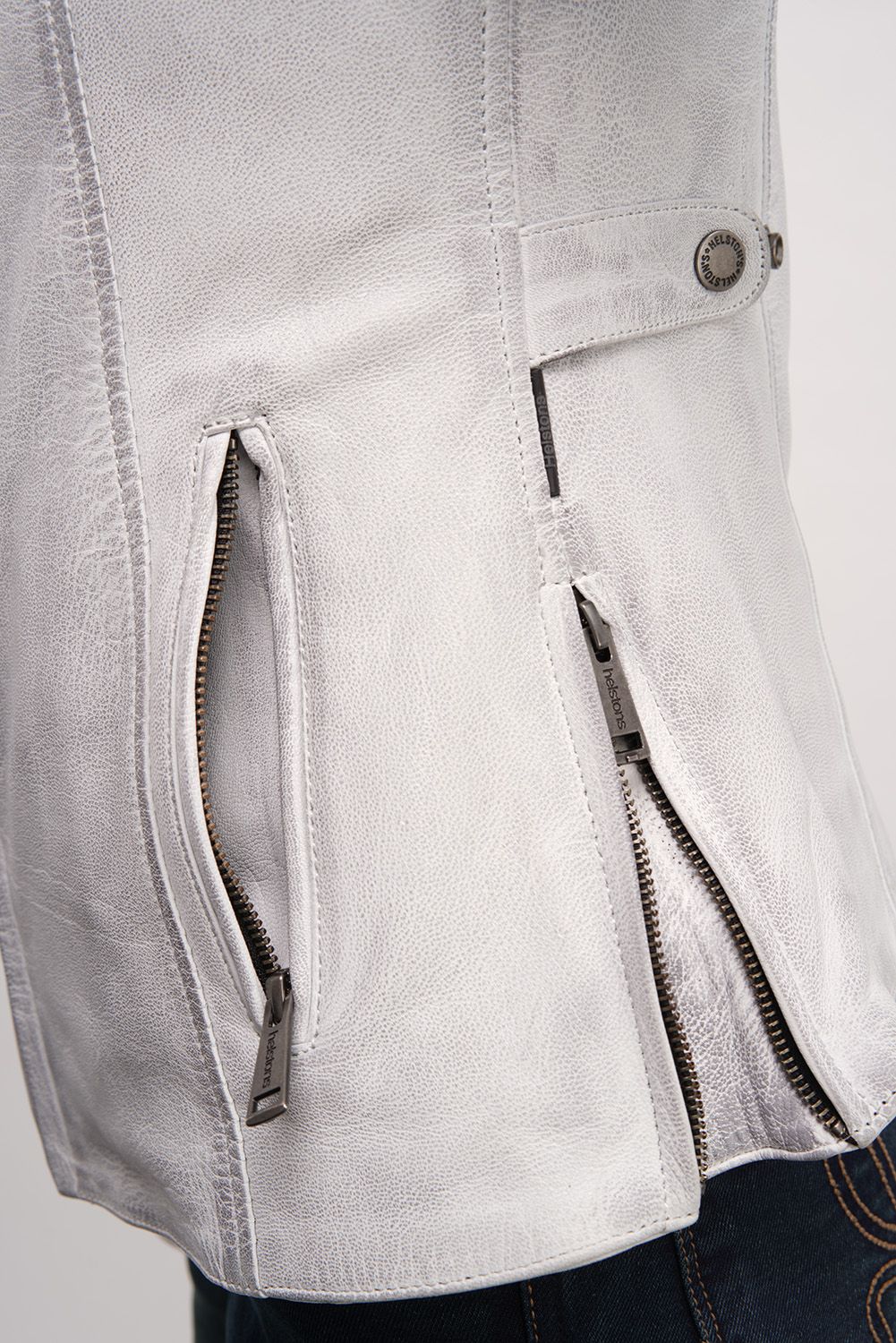 a close up of the side zipper of white leather jacket