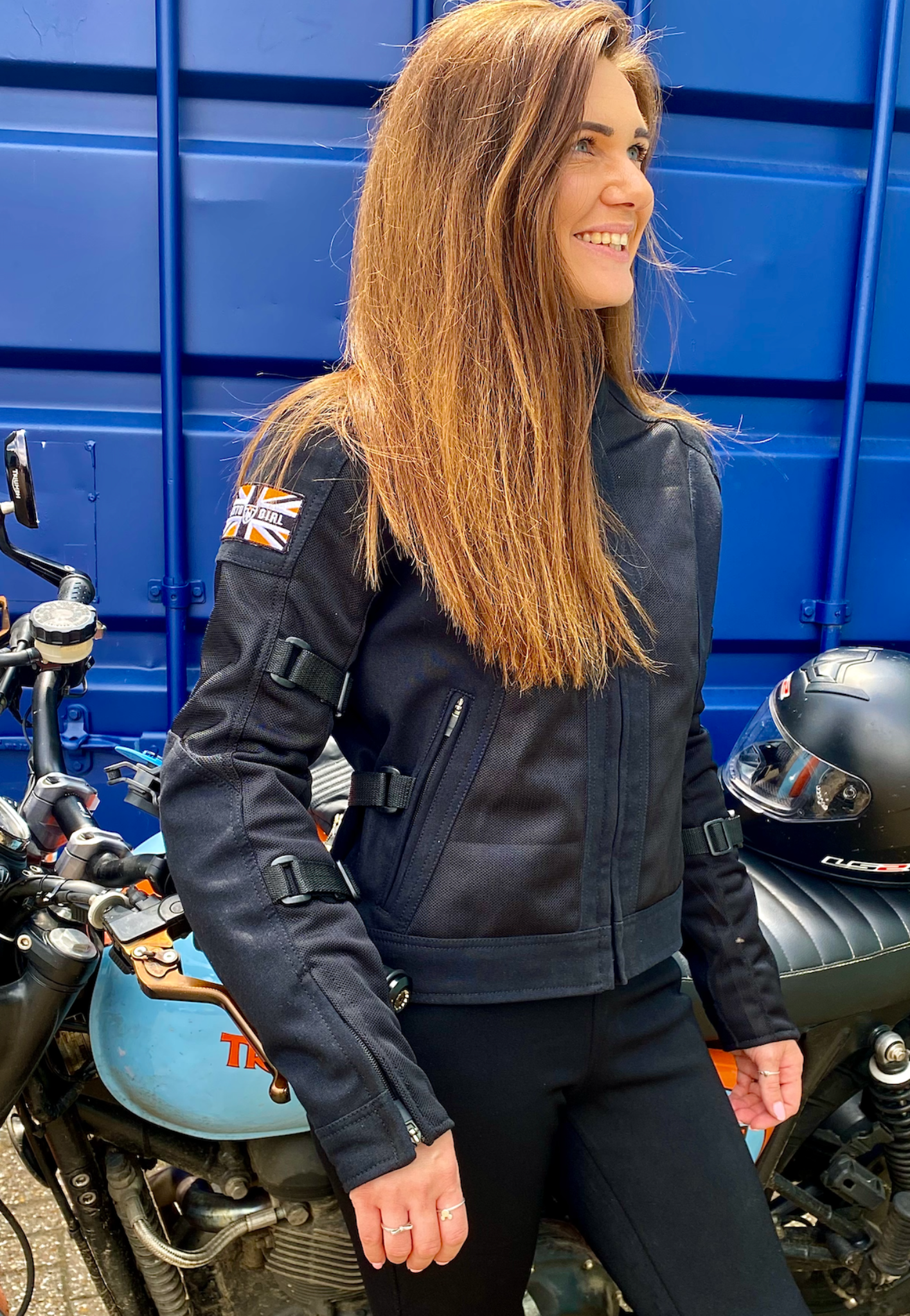 A smiling woman wearing Black summer mesh women&#39;s motorcycle jacket with Motogirl patch