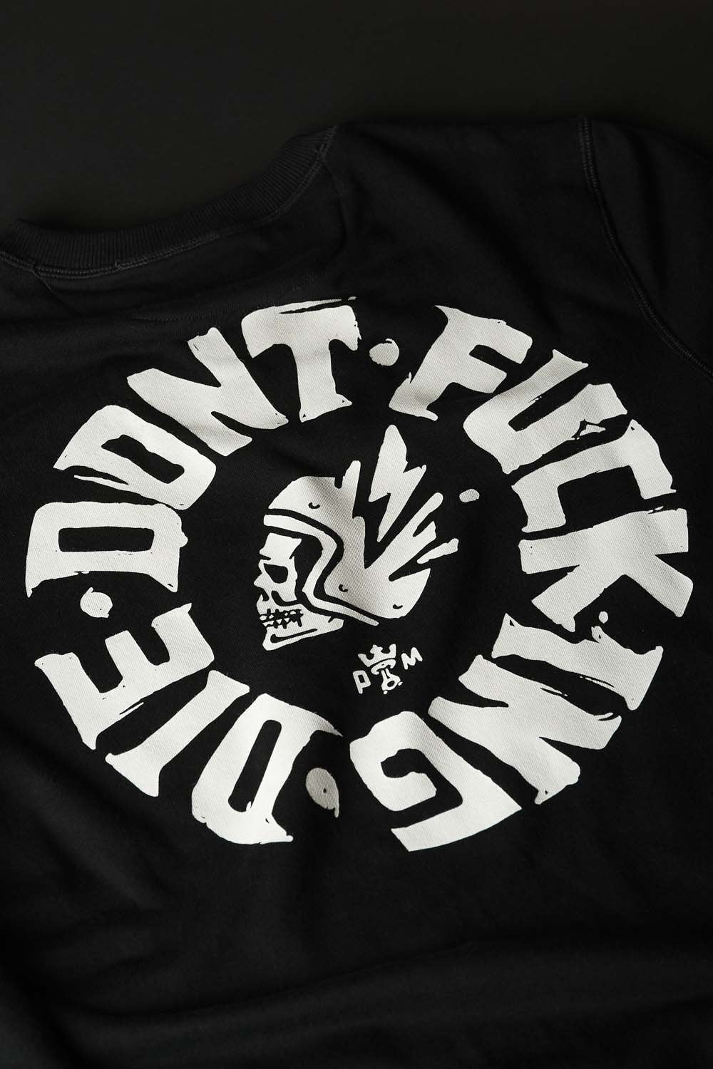 A close up of the Don&#39;t fucking die motive on the black Pando Moto motorcycle sweatshirt 