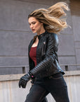 A blond woman  wearing Black leather motorcycle jacket for women from Shima